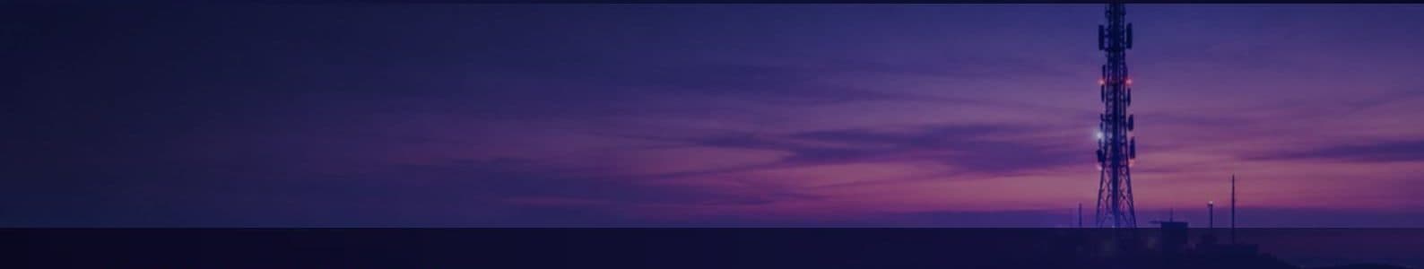 A telecom tower on the horizon at dusk